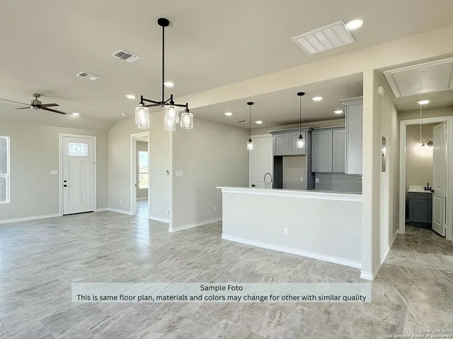 a view of a big room with kitchen and chandelier