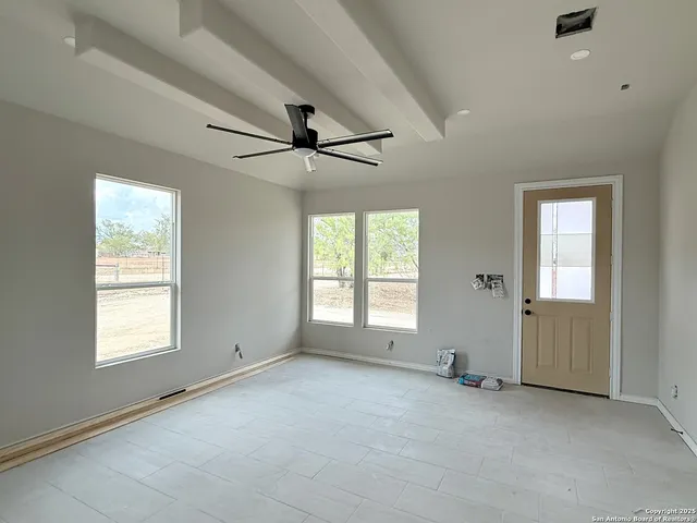 an empty room with windows and fan