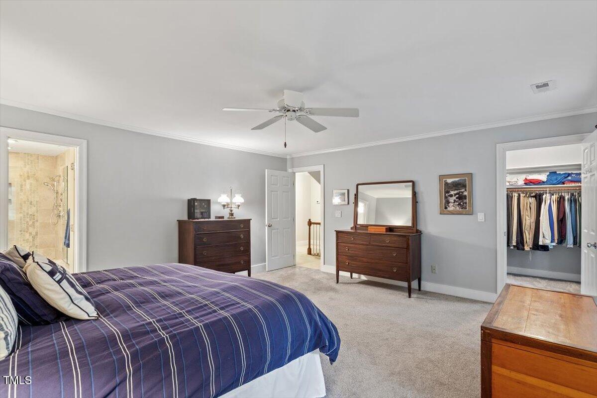 12329 Whartons Way Raleigh, NC 27613 - Photo 24 of 51 a bedroom with a bed and a chandelier