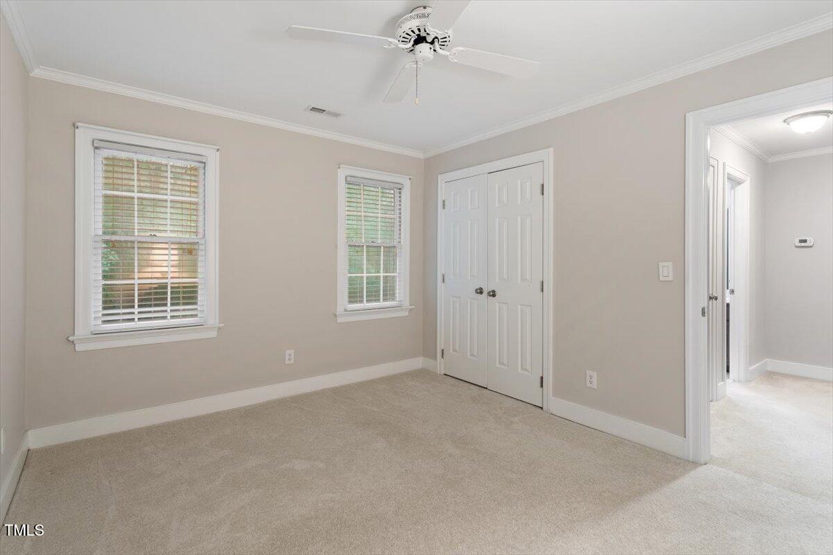 12329 Whartons Way Raleigh, NC 27613 - Photo 29 of 51 an empty room with a ceiling fan and windows