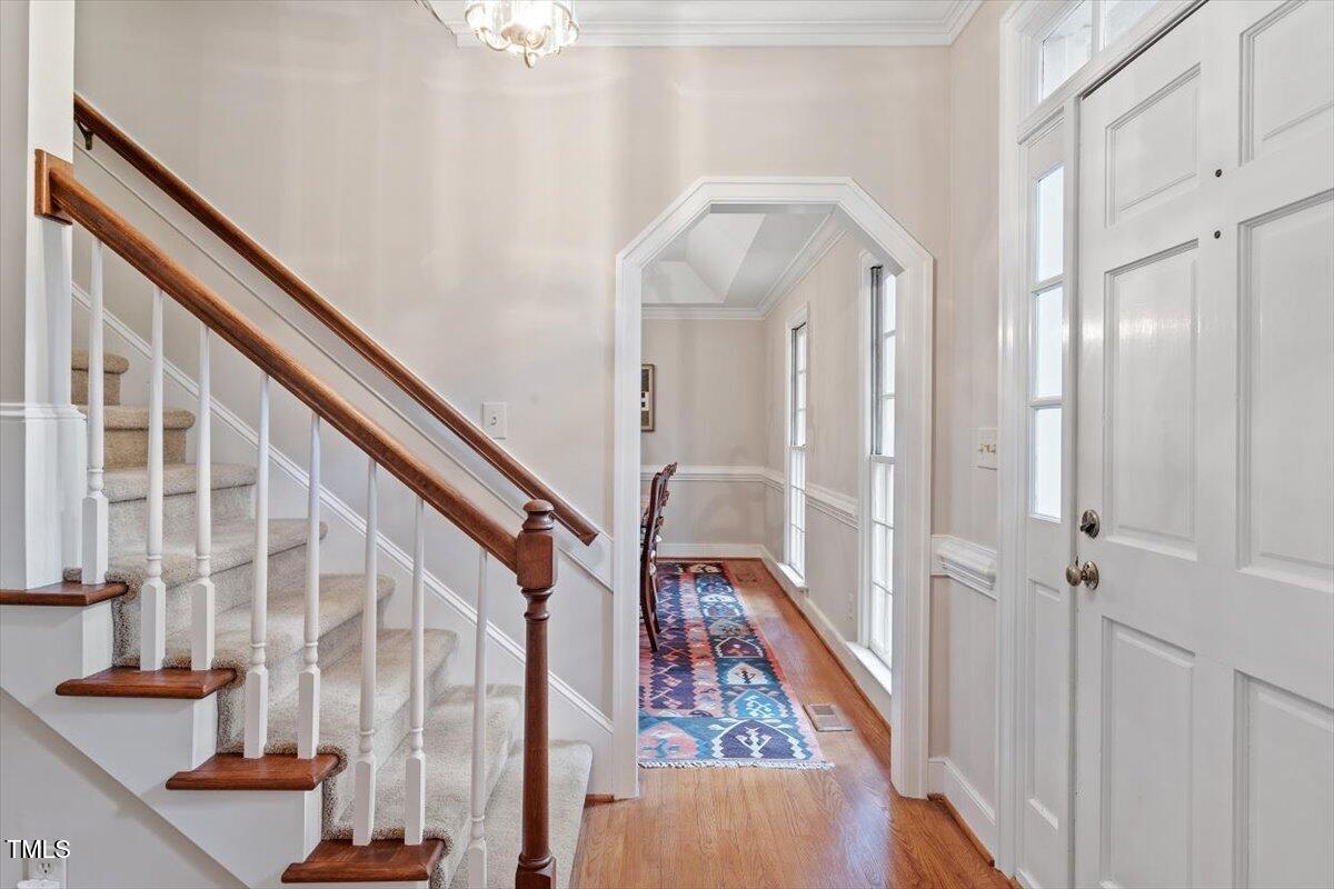 12329 Whartons Way Raleigh, NC 27613 - Photo 4 of 51 a view of staircase with lots of frames on wall and wooden floor