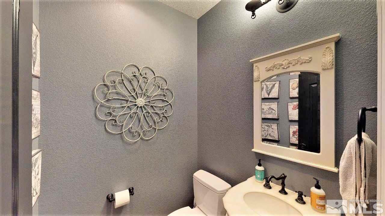 671 Caspian Court Reno, NV 89521 - Photo 23 of 33 a bathroom with a toilet sink and mirror