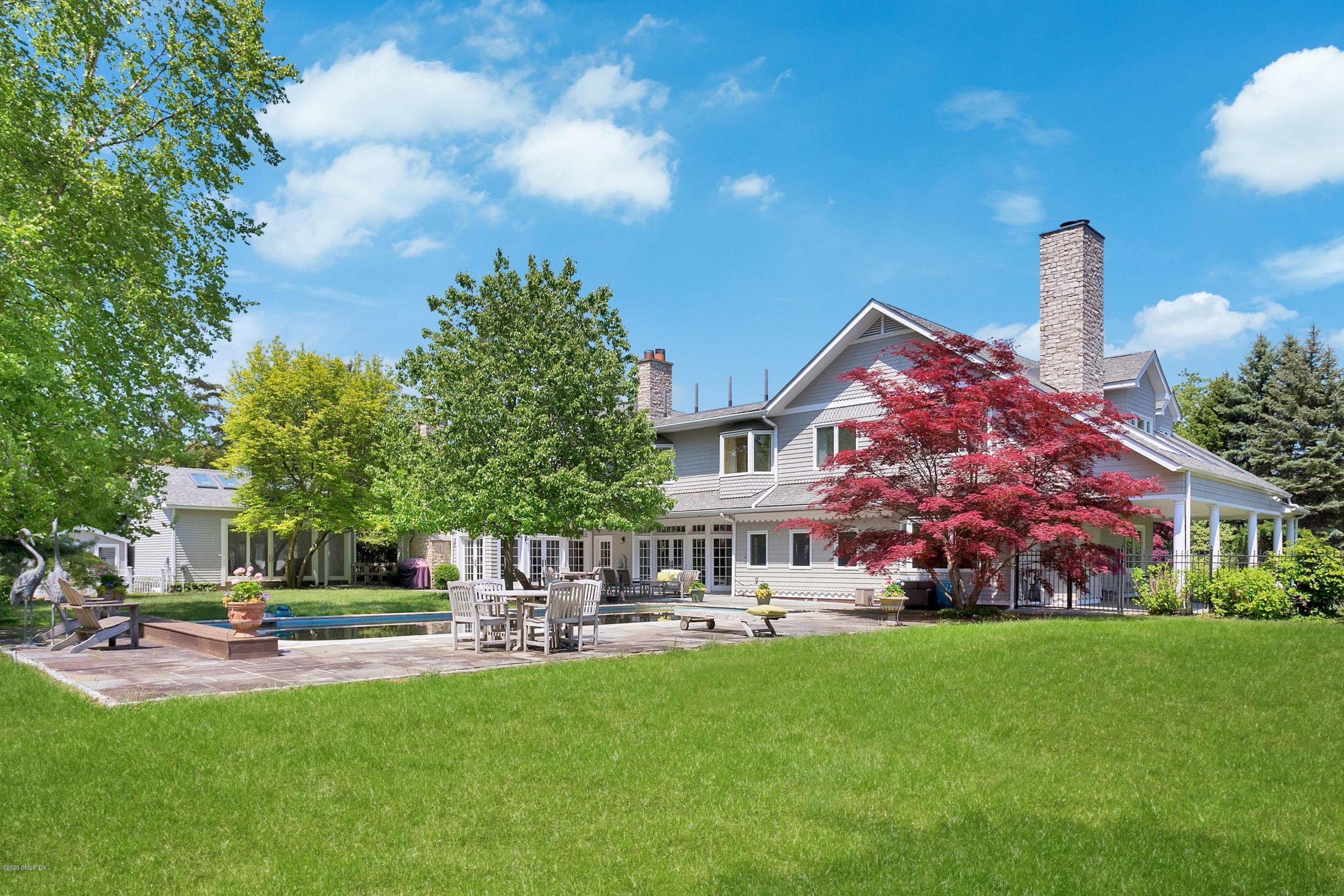 188 Otter Rock Drive Greenwich, CT 06830 - Photo 16 of 23 a front view of a house with garden and trees