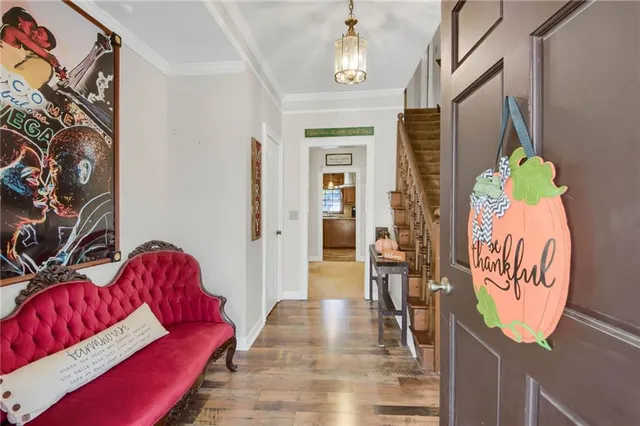 a view of a dining room and livingroom with furniture wooden floor a chandelier