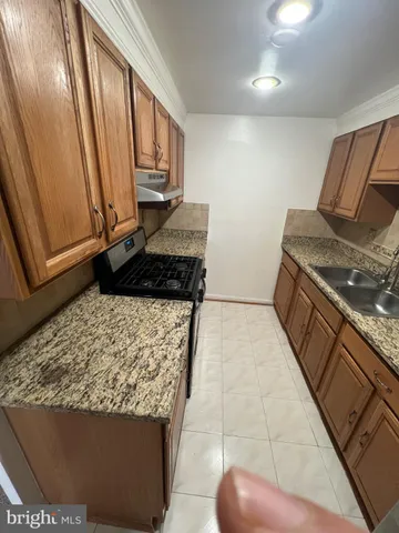 a kitchen with stainless steel appliances granite countertop a refrigerator and a stove