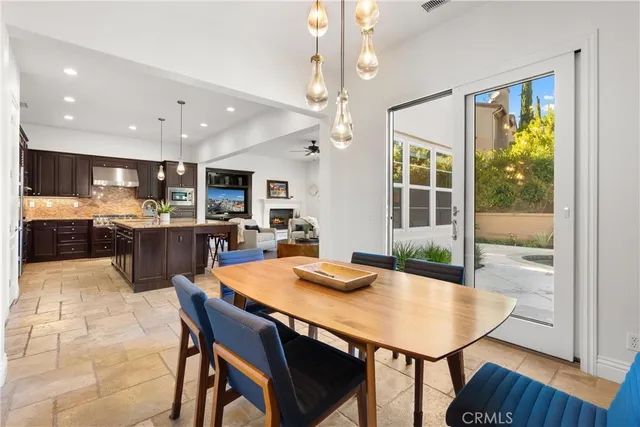 a kitchen with granite countertop a table chairs stainless steel appliances and cabinets
