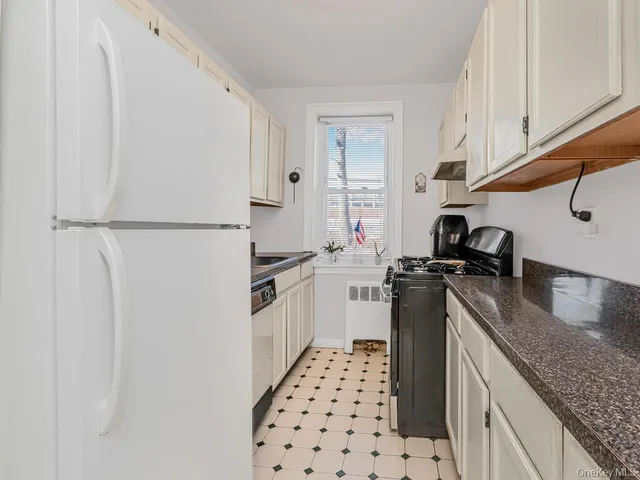 a kitchen with a sink a refrigerator and cabinets