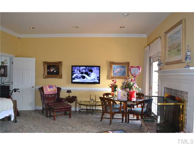 86 Dogeye Road Benson, NC 27504 - Photo 2 of 24 A bright family room is off the kitchen. Gorgeous crown molding and a unique chair rail add a touch of elegance to a warm and inviting space. A remote controlled gas fireplace adds comfort and style.