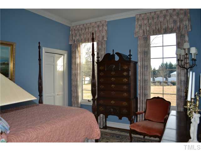 86 Dogeye Road Benson, NC 27504 - Photo 11 of 24 A guest bedroom with hardwood floors sits at the back of the house and enjoys a lovely view of the backyard.