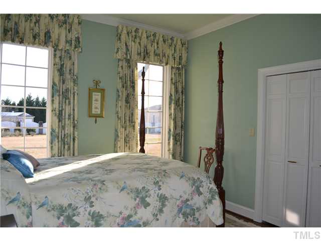 86 Dogeye Road Benson, NC 27504 - Photo 13 of 24 A bedroom with a large double door closet and hardwood floors gets lots of natural light throughout the day.