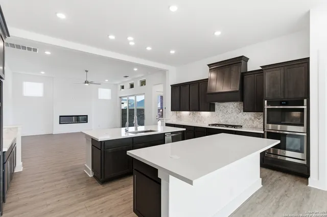 a large kitchen with stainless steel appliances kitchen island a large counter top and a sink