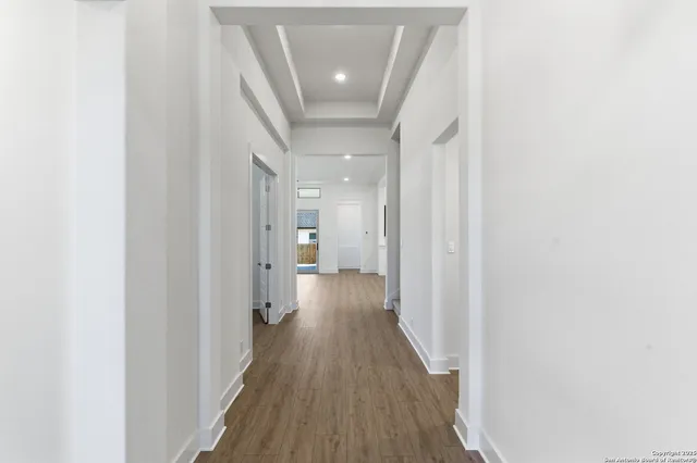 a view of a hallway with wooden floor