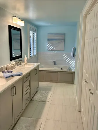 a spacious bathroom with a bathtub sink and mirror
