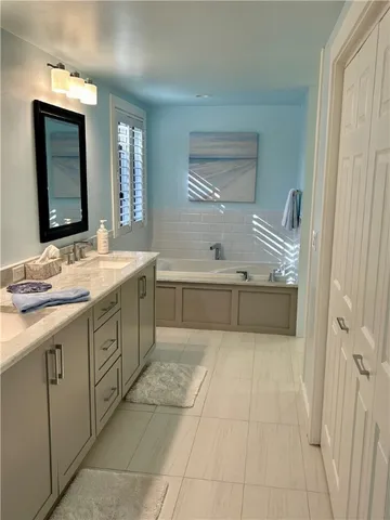 a spacious bathroom with a bathtub sink and mirror