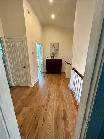 a view of a hallway with wooden floor and staircase