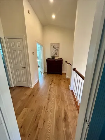a view of a hallway with wooden floor and staircase