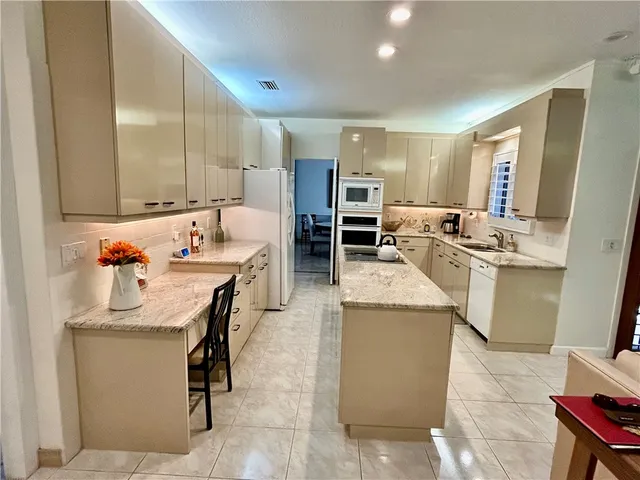 a room with stainless steel appliances kitchen island a table and chairs in it