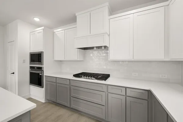 a kitchen with white cabinets and appliances