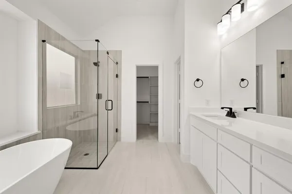 a spacious bathroom with a double vanity sink toilet mirror and shower