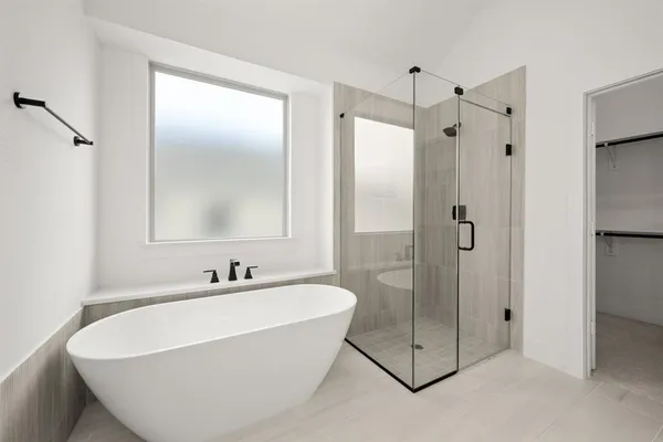 a bathroom with a tub shower and sink