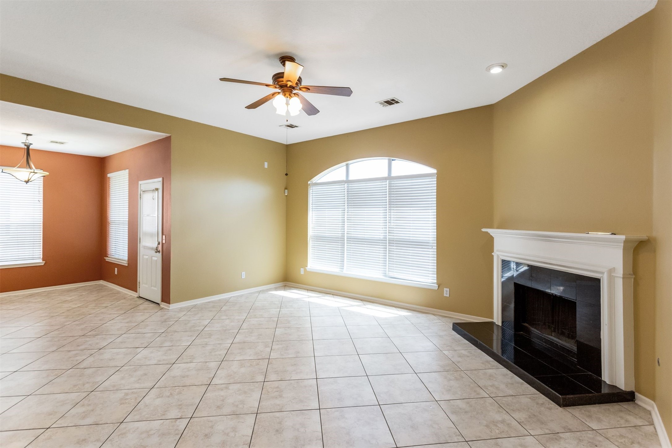 9818 Mossy Tree Lane Houston, TX 77064 - Photo 12 of 28 a view of an empty room with a fireplace and a window