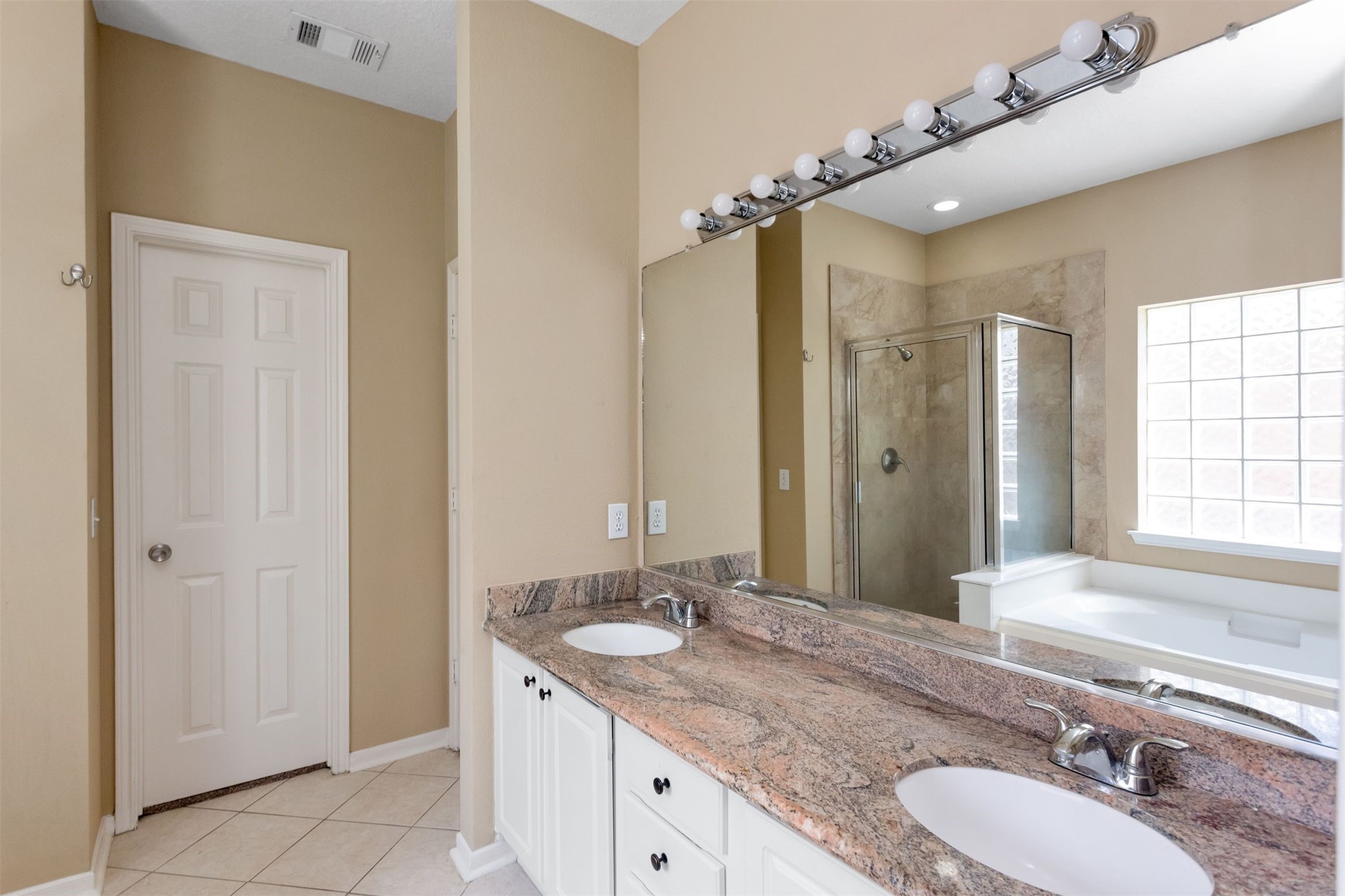 9818 Mossy Tree Lane Houston, TX 77064 - Photo 16 of 28 a bathroom with a granite countertop bathtub sink double and mirror