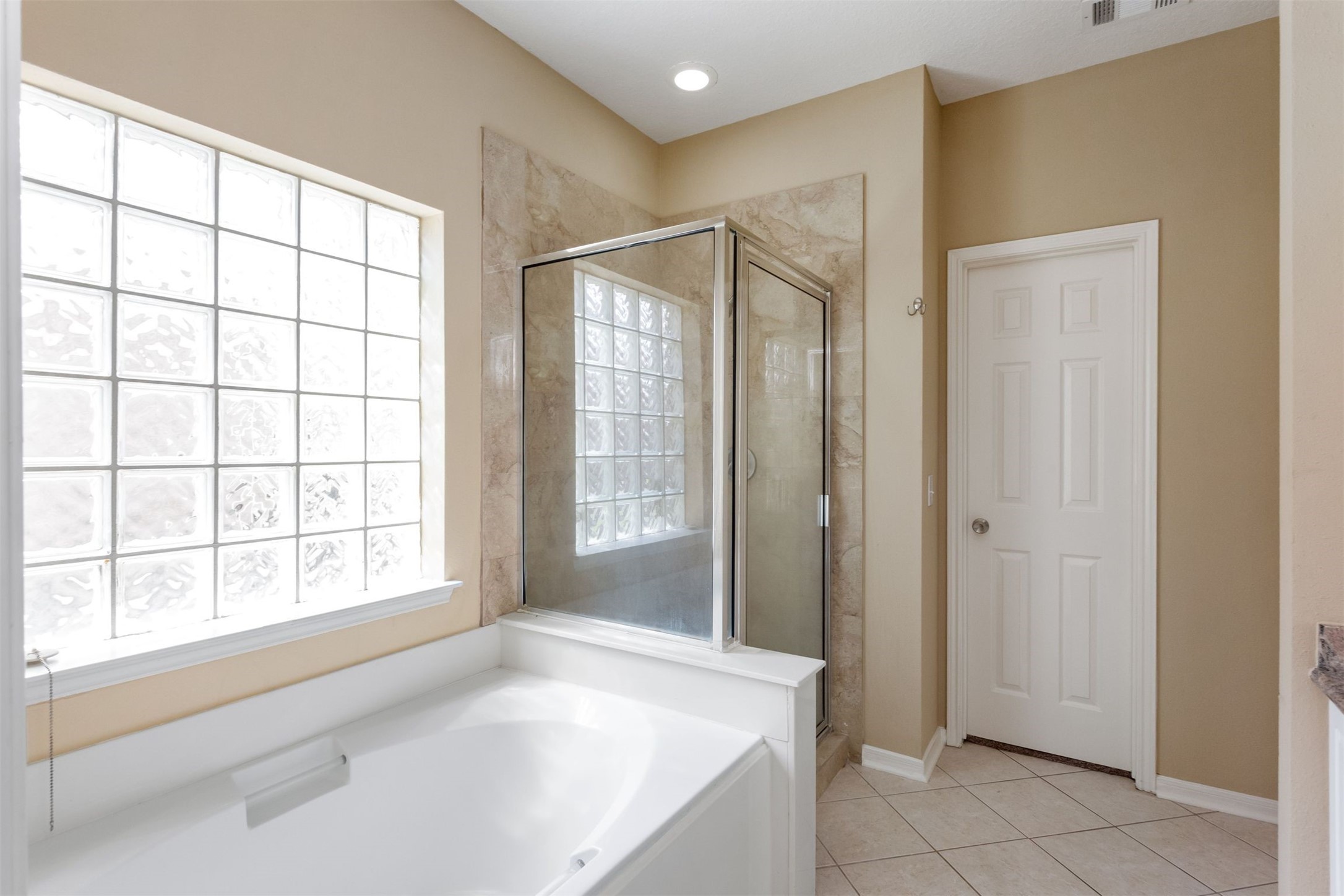 9818 Mossy Tree Lane Houston, TX 77064 - Photo 17 of 28 a spacious bathroom with a bathtub and a shower