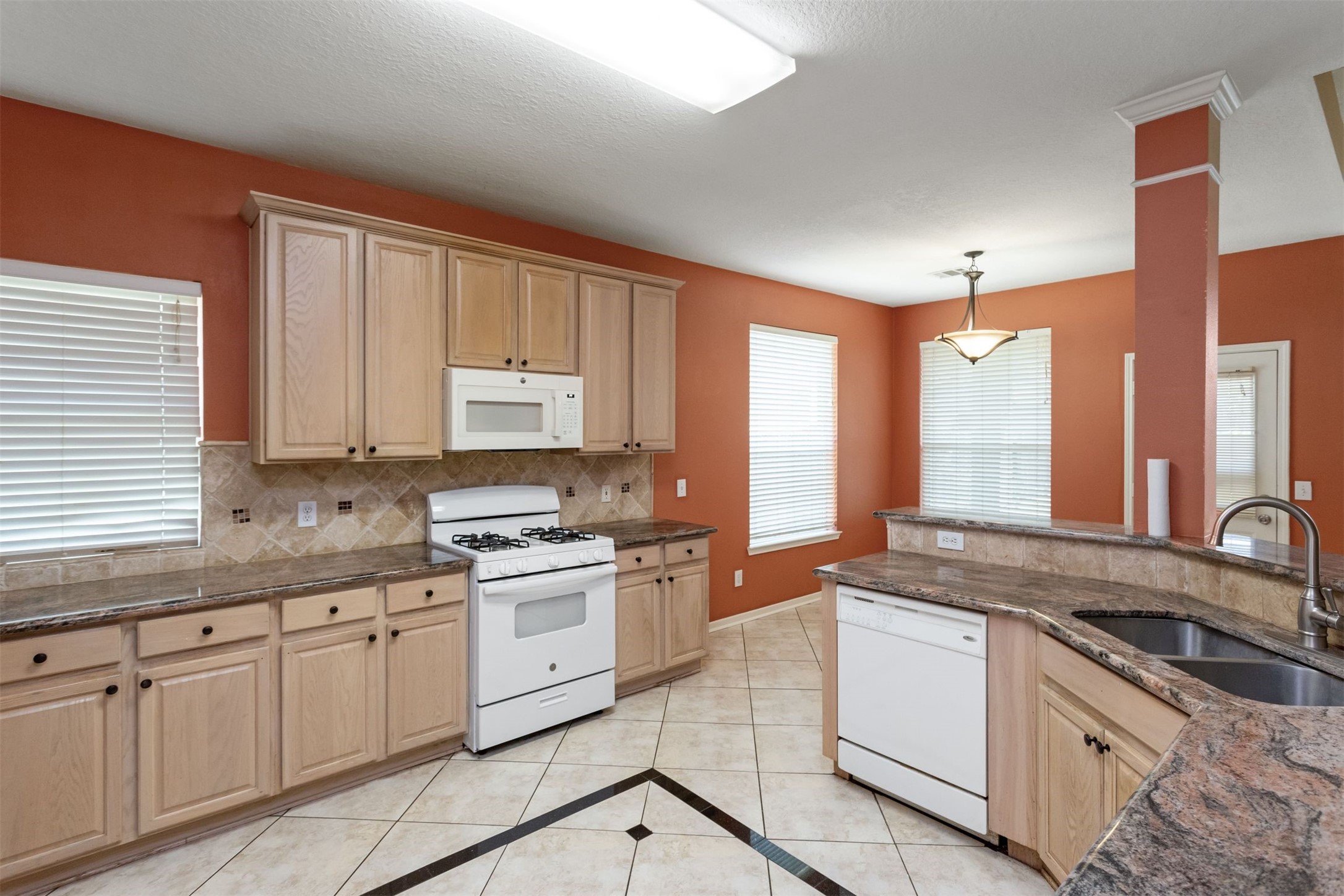 9818 Mossy Tree Lane Houston, TX 77064 - Photo 6 of 28 a kitchen with granite countertop a sink stove and cabinets