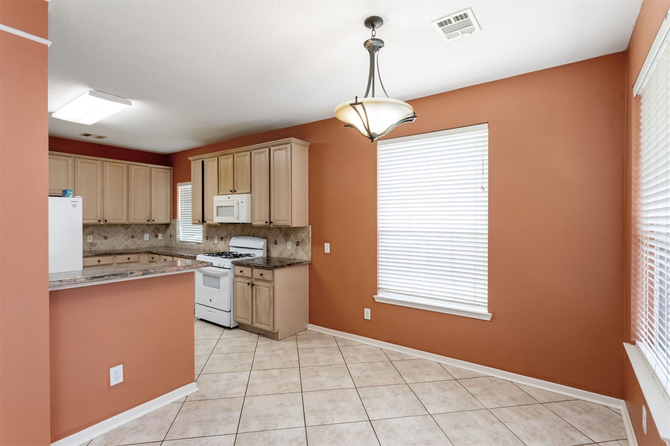 9818 Mossy Tree Lane Houston, TX 77064 - Photo 8 of 28 a kitchen that has a sink a window and stainless steel appliances