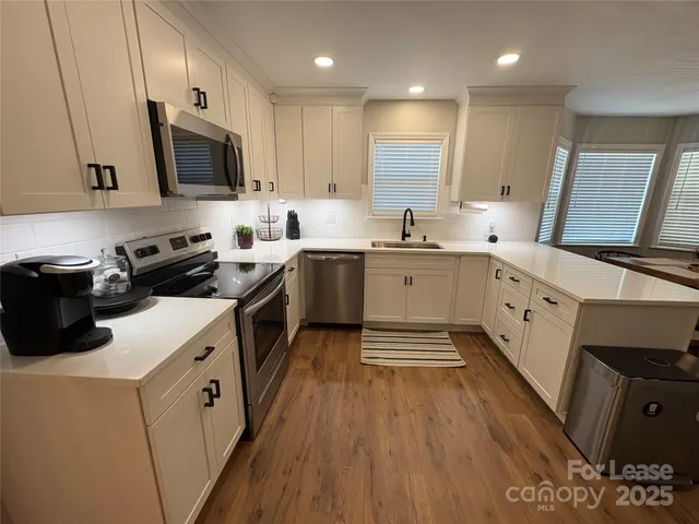 a kitchen with a sink a stove and cabinets