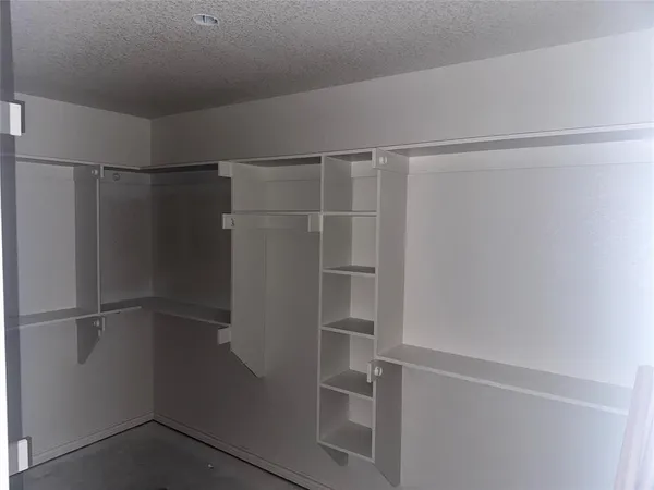 a view of walk in closet with empty racks