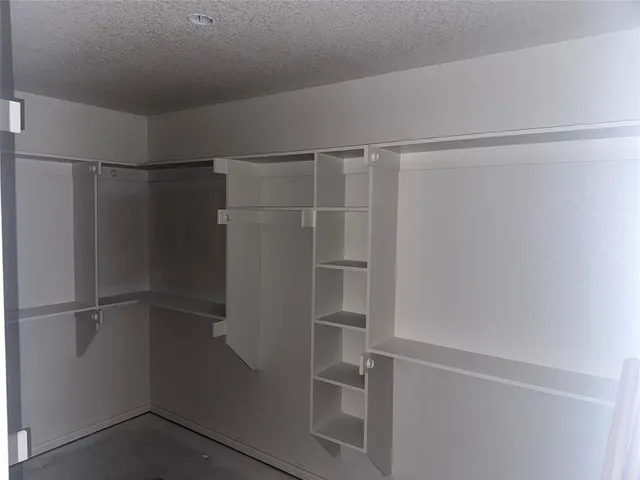 a view of walk in closet with empty racks