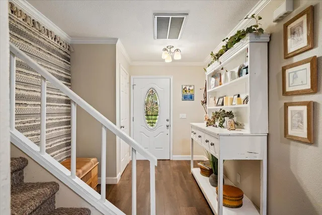 a view of a hallway with wooden floor and staircase