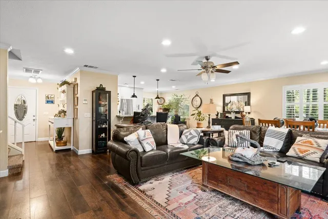 a living room with furniture kitchen view and a large window