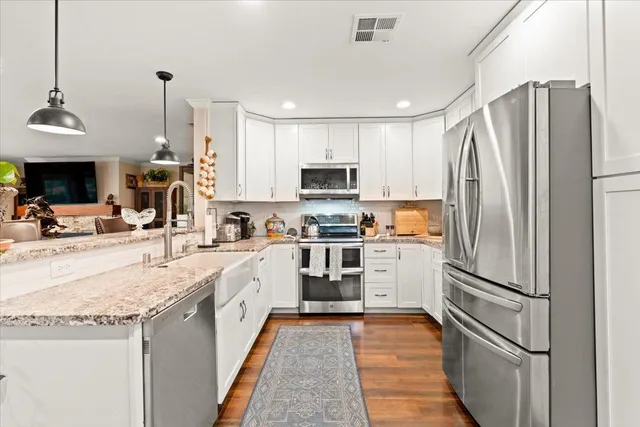 a kitchen with granite countertop a refrigerator oven a sink and dishwasher