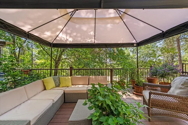 a balcony with furniture and a umbrella