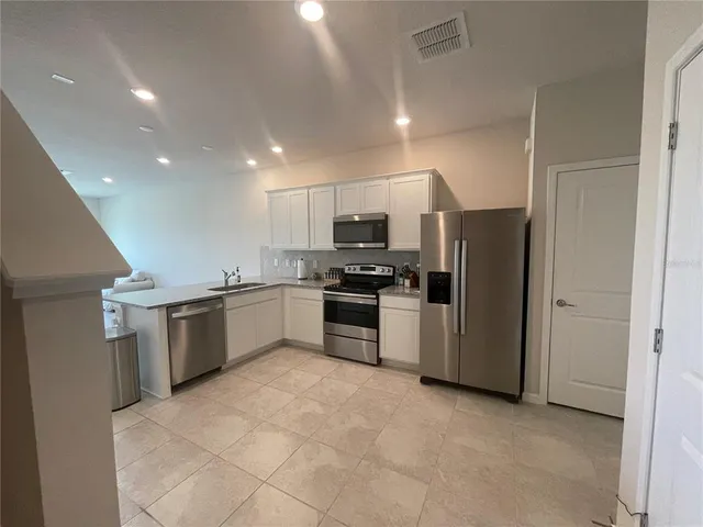 a kitchen with a refrigerator and a stove top oven