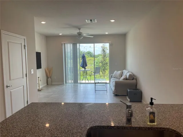 a living room with furniture and a floor to ceiling window