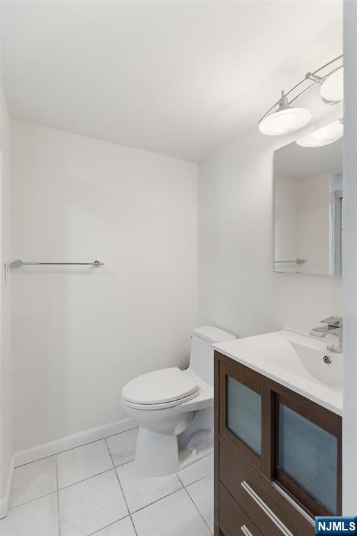 301 Beech Street, Unit 9K Hackensack, NJ 07601 - Photo 15 of 24 a bathroom with a sink a toilet and a mirror