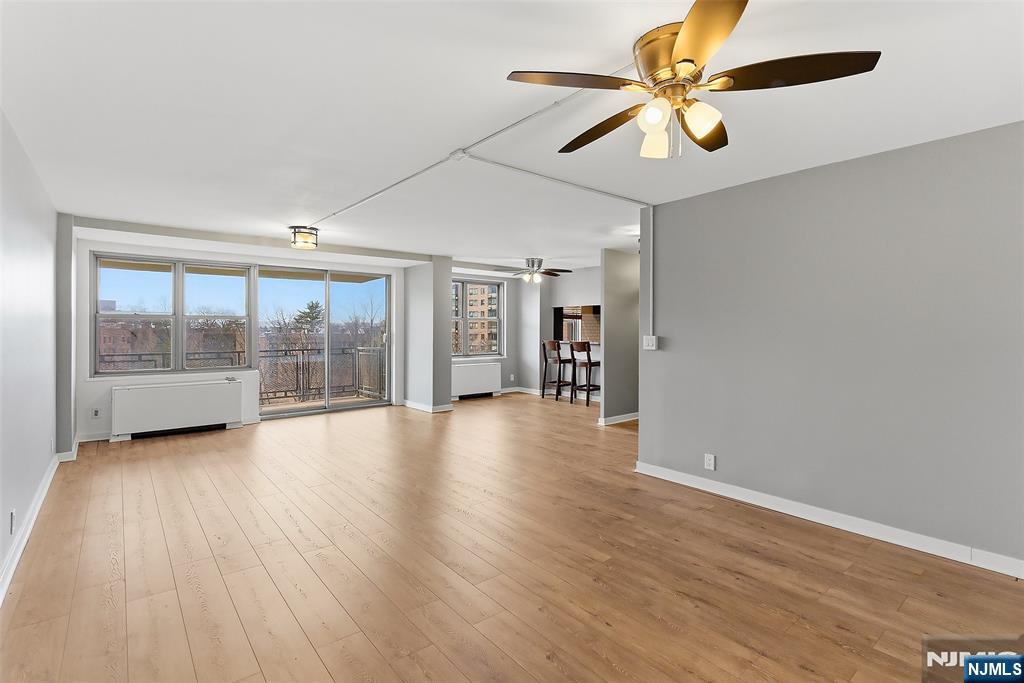 301 Beech Street, Unit 9K Hackensack, NJ 07601 - Photo 9 of 24 a view of an empty room with a window and wooden floor