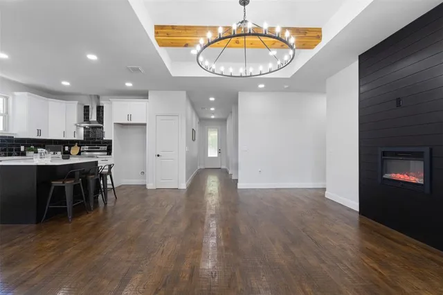 a kitchen with a dining table chairs and wooden floor