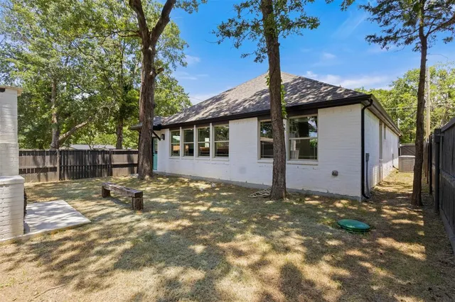 a view of a house with a yard and wooden fence