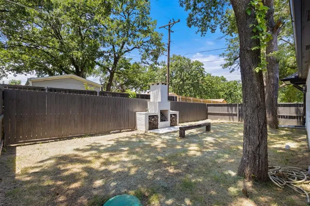 a view of a house with backyard and tree