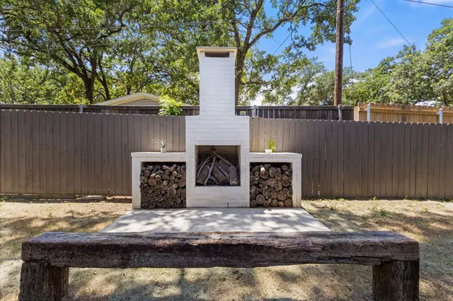 a backyard of a house with table and chairs under an umbrella