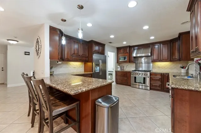 a kitchen with granite countertop kitchen island granite countertop wooden cabinets and stainless steel appliances