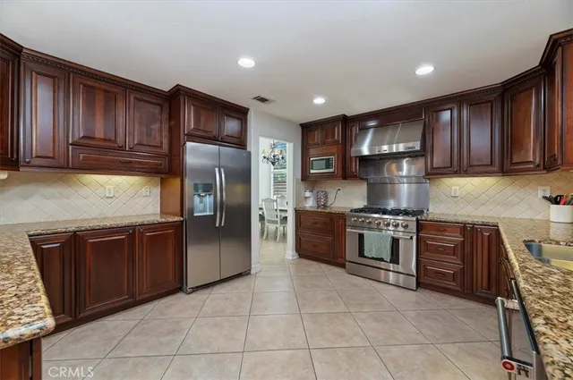 a kitchen with stainless steel appliances granite countertop wooden cabinets a stove top oven a sink and dishwasher