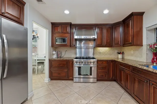 a kitchen with stainless steel appliances granite countertop a refrigerator stove and sink