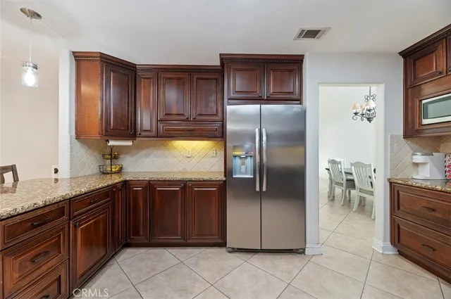 a kitchen with granite countertop stainless steel appliances a refrigerator and a sink