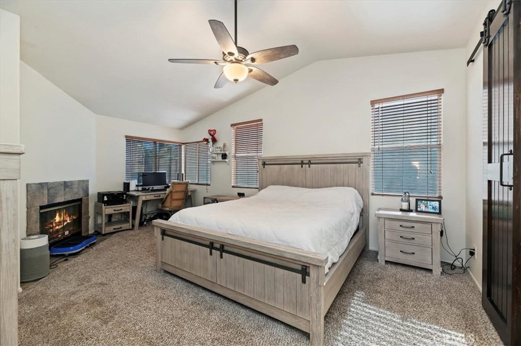 1040 Nighthawk Circle Corona, CA 92881 - Photo 28 of 39 a spacious bedroom with a bed a fireplace and a chandelier