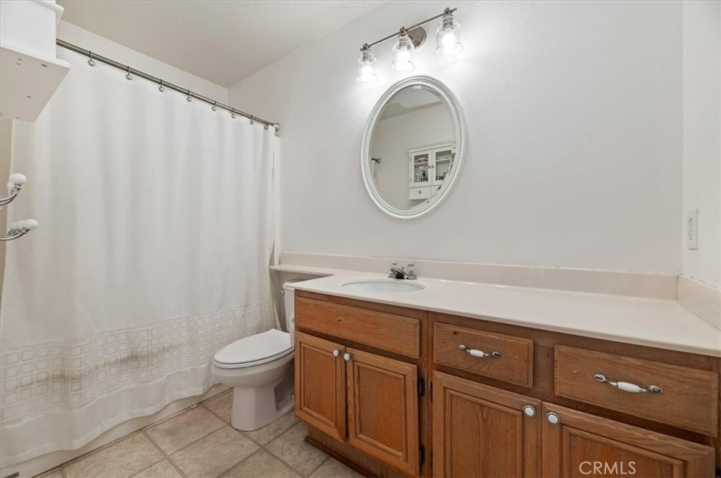 1040 Nighthawk Circle Corona, CA 92881 - Photo 34 of 39 a bathroom with a granite countertop toilet and a sink